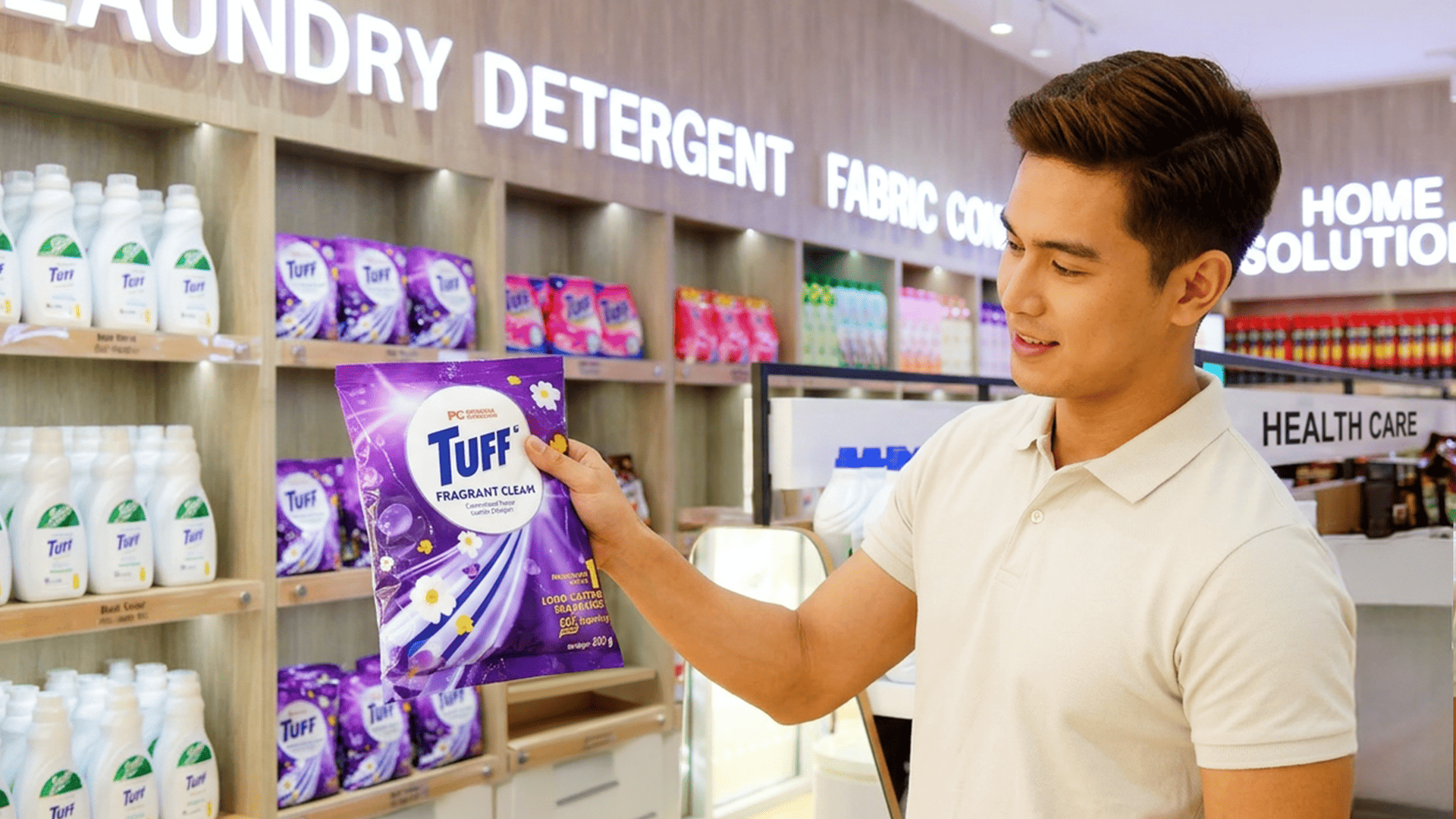 Man inside a grocery store holding Tuff powdered detergent